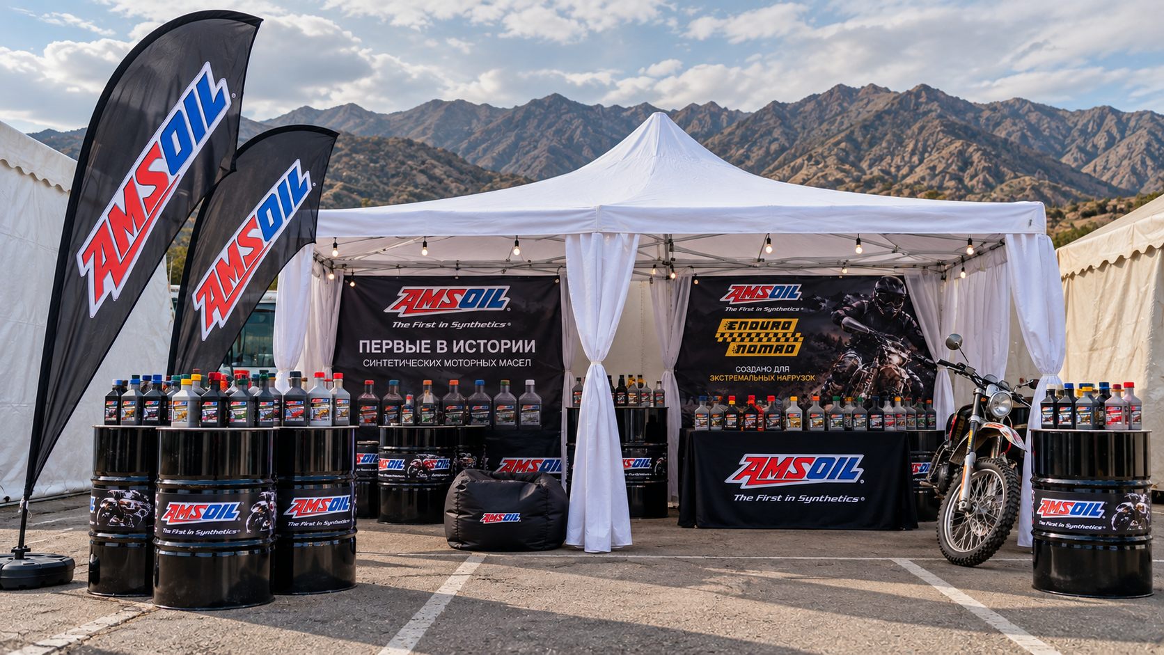Бренд-зона AMSOIL на фестивале Enduro Nomad: шатёр с продукцией, флаги и мотоцикл на фоне гор